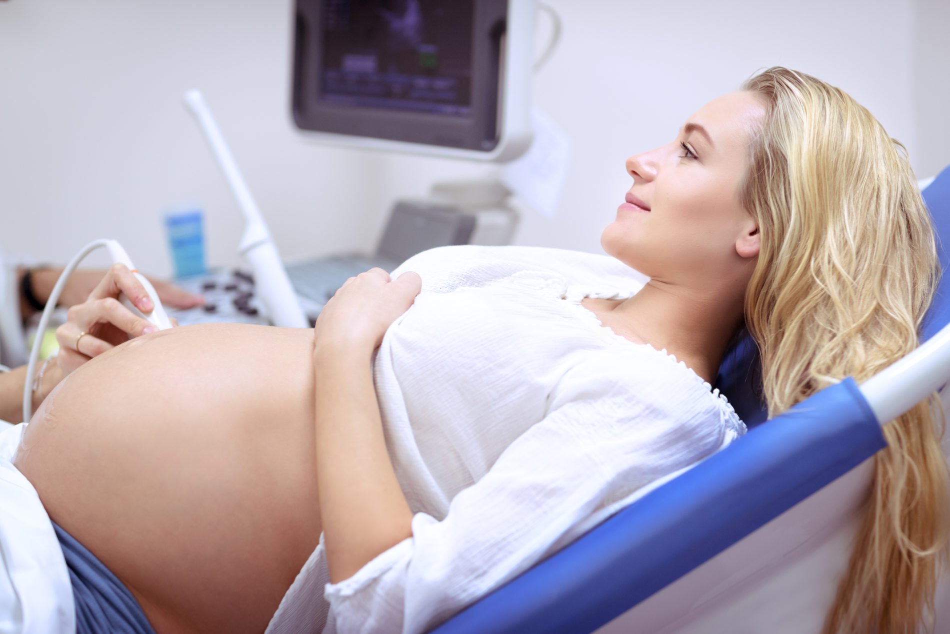 Pregnant woman on ultrasound, responsible mother checking health of her baby in the belly, health care on third trimester, sonography in the good medical clinic